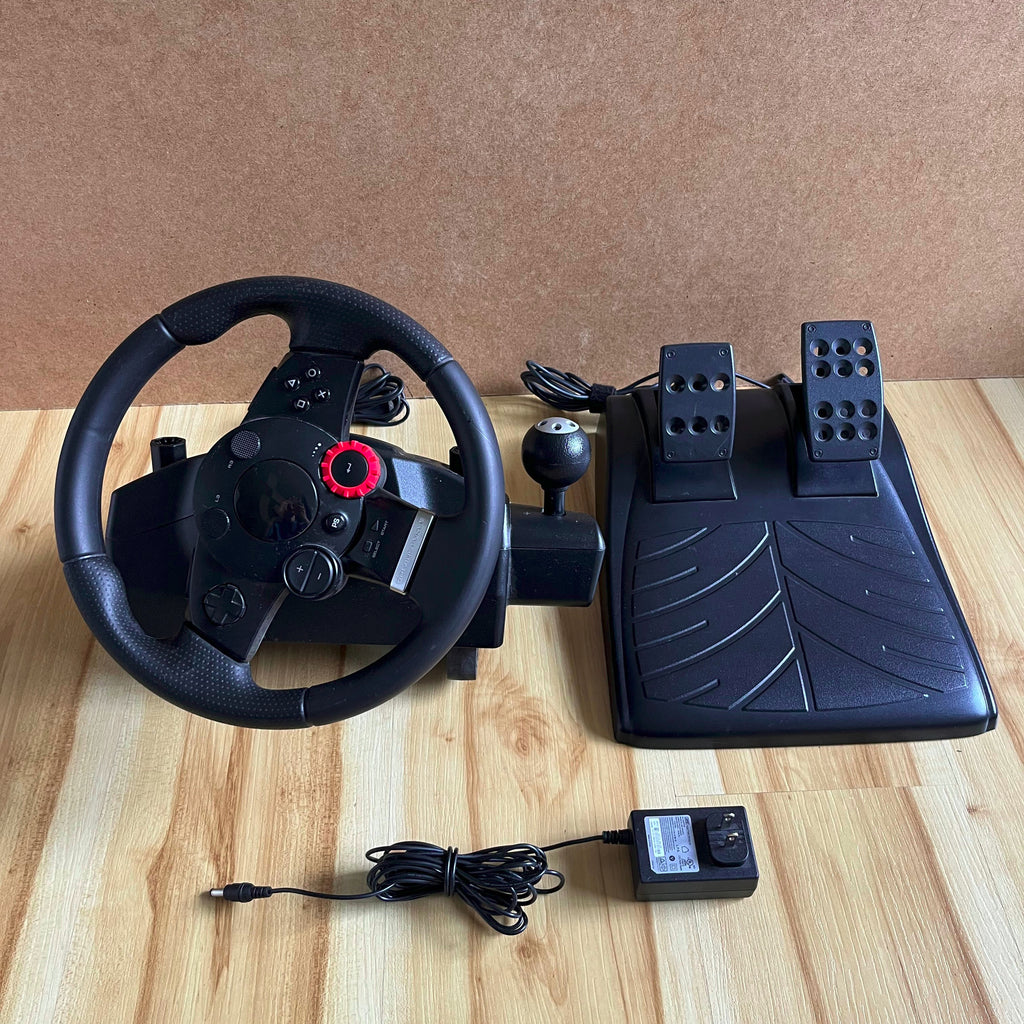 Black steering wheel and pedals set on a wooden surface with a brown background