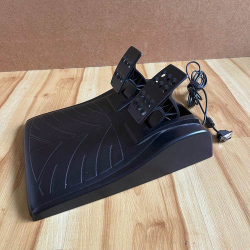 Black pedal assembly for racing wheel setup with wiring on a wooden surface