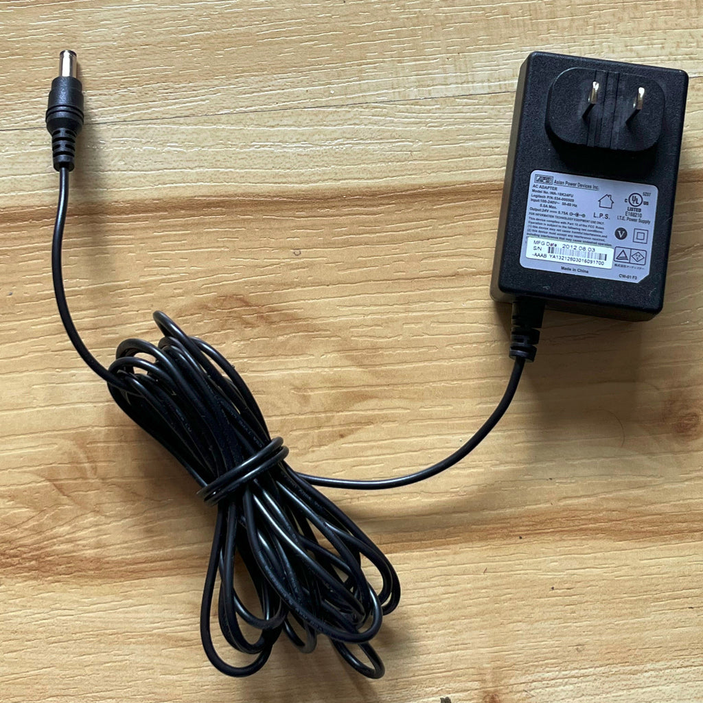 Black power adapter with cable on a wooden surface