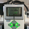 Close-up of the Lego Mindstorms EV3 digital display and green light on a white and gray device.