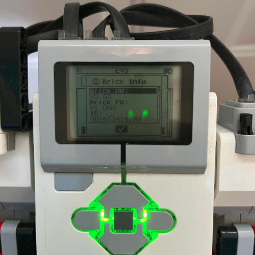 Close-up of the Lego Mindstorms EV3 digital display and green light on a white and gray device.